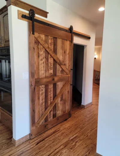A barn door in a room with hardwood floors.
