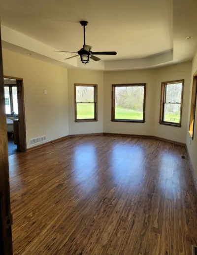 A living room with hardwood floors and a ceiling fan.