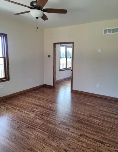 A room with hardwood floors and a ceiling fan.