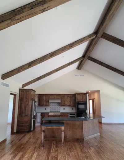 A kitchen with wooden beams and hardwood floors.