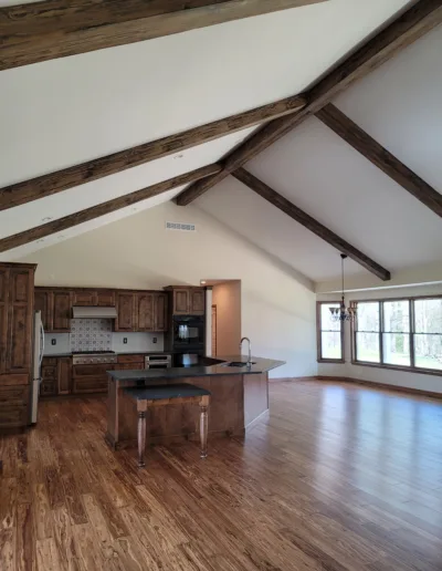 A kitchen with wood beams and hardwood floors.