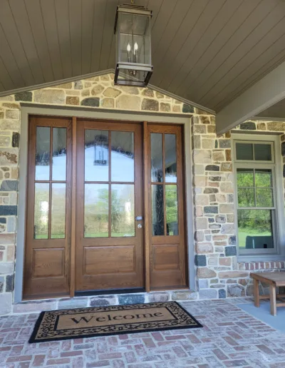 A stone front porch with a wooden door.