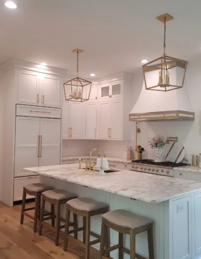 A white kitchen with a center island and stools.