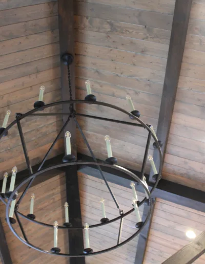 A chandelier hanging from a wooden ceiling.