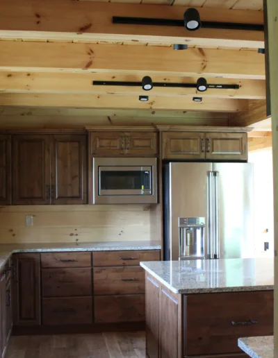 A view of a kitchen in a log cabin.