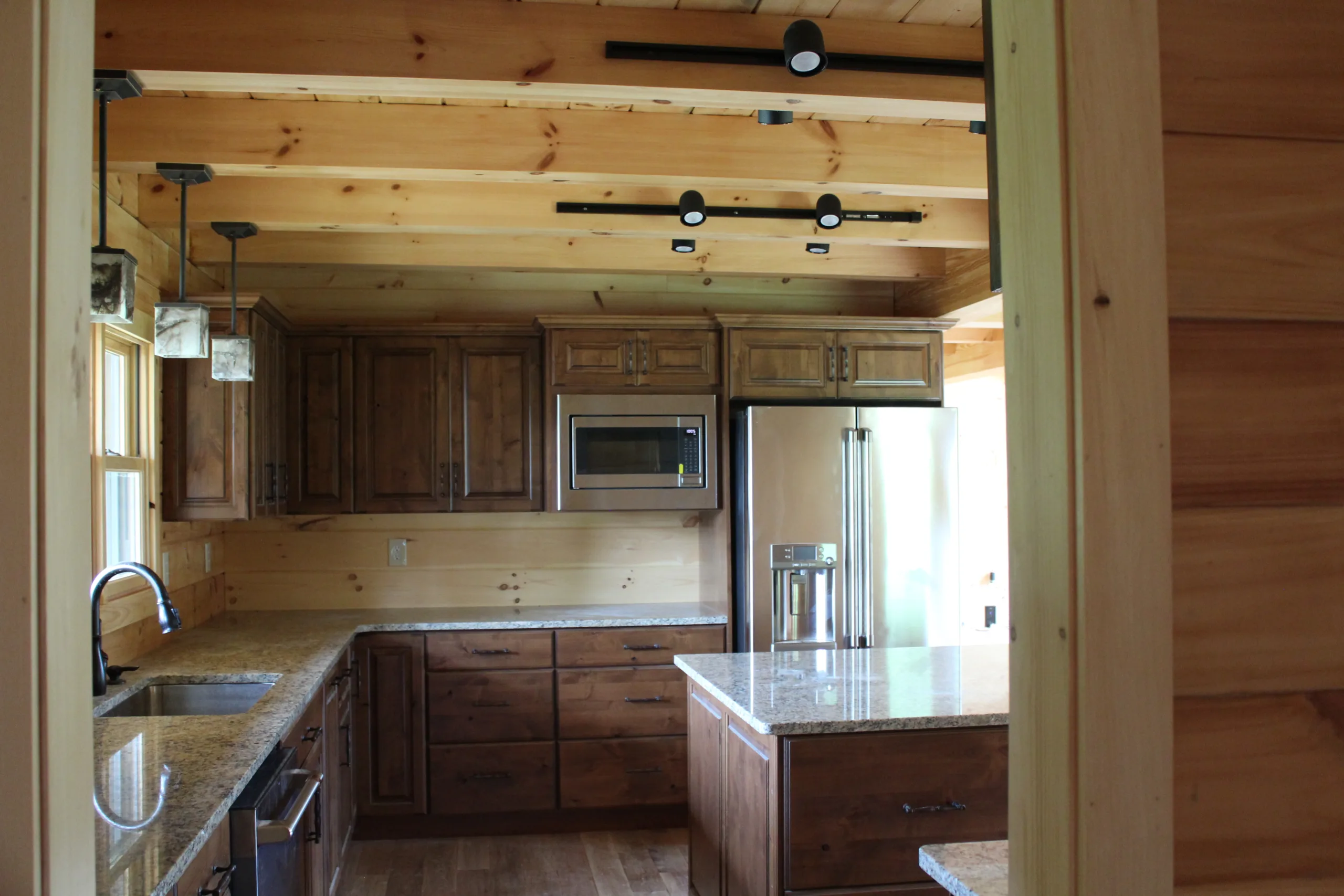 A view of a kitchen in a log cabin.