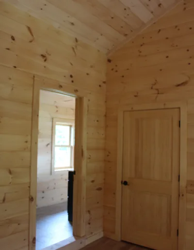 A room with wooden walls and a door.