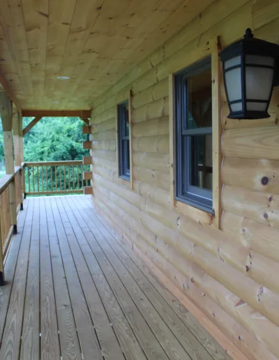 A wooden porch on a log home.