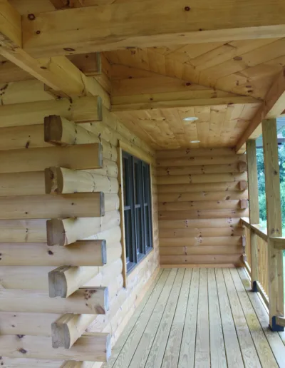 A wooden porch on a log cabin.