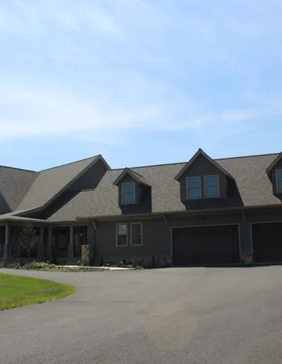 A large gray house with a driveway and garage.